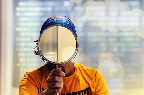 Una persona che guarda il proprio riflesso in uno specchio con un sorriso, mostrando una pelle radiosa