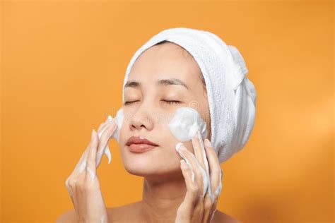 Donna che si lava il viso con un detergente schiumoso