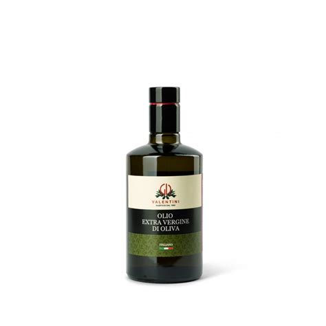 Bottiglia di olio extra vergine di oliva accanto a frutta e verdura fresche