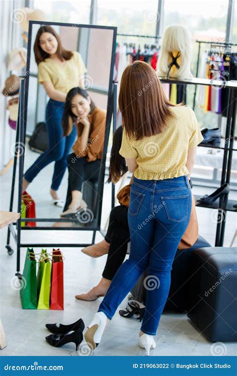 Donne che provano abiti eleganti in un showroom