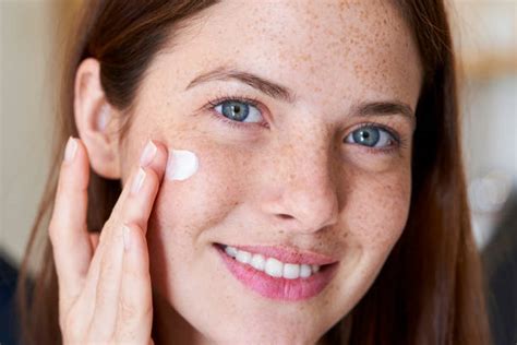 Donna che applica crema sul viso