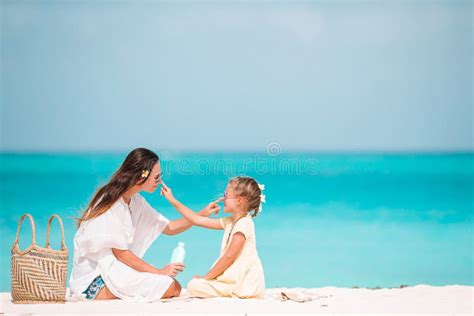 Persona che applica crema solare sulla spiaggia
