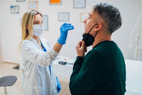 Immagine di un medico che esegue un tampone faringeo su un paziente