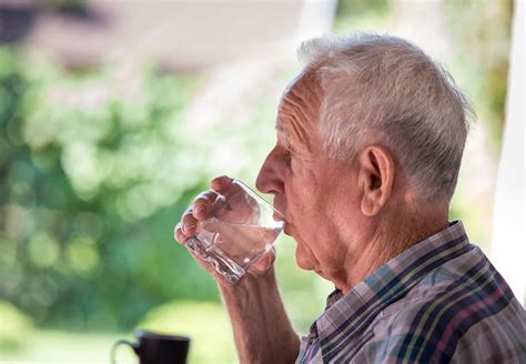 Anziano che beve acqua