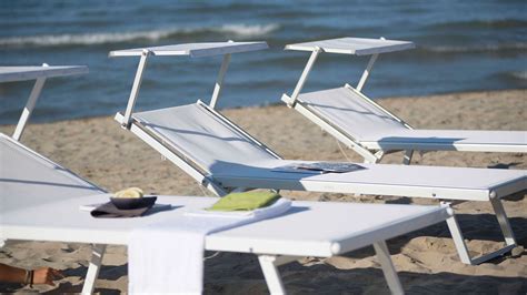 Uomo e donna abbronzati che si rilassano su lettini da spiaggia