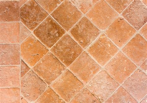 Immagine di un pavimento in cotto con incrostazioni di calcare e cemento, e accanto lo stesso pavimento pulito