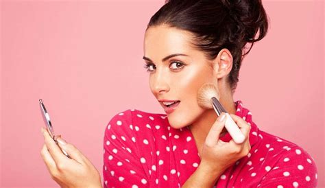 Una donna che applica il fard con un pennello