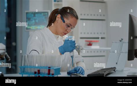 Biologo che lavora in laboratorio con provette e microscopio