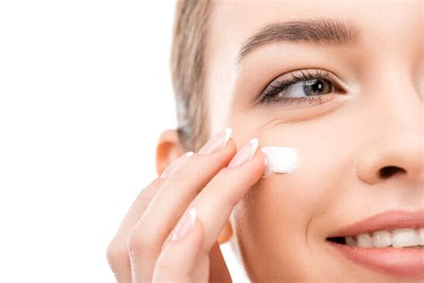 Donna che applica crema antirughe sul viso