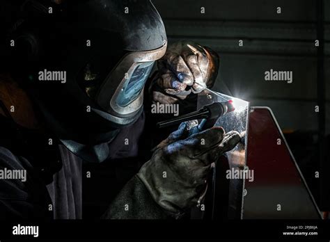 Un saldatore al lavoro con la sua maschera protettiva.