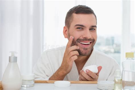 Uomo che applica crema addominale