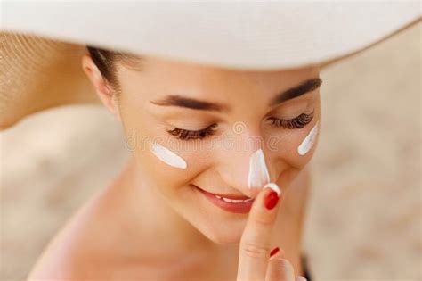 giovane donna che applica crema solare sul viso