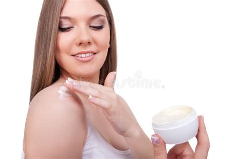 Una donna che applica una crema corpo su gambe e fianchi.