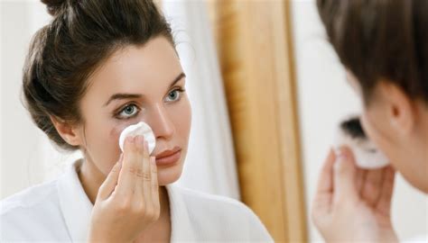 Una donna che si strucca il viso delicatamente con un latte detergente