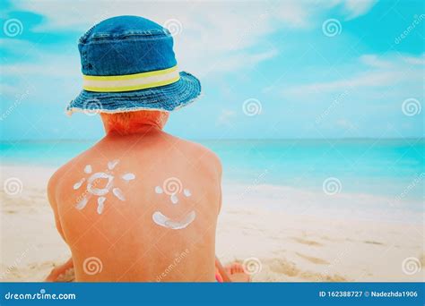 Bambino con crema solare sulla spiaggia