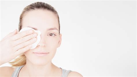 Donna che si strucca il viso con latte detergente