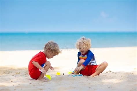 bambini che giocano in spiaggia con cappelli