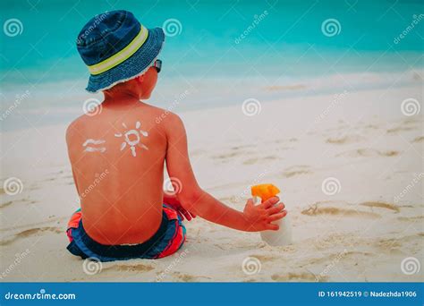 Bambino che gioca in spiaggia con crema solare