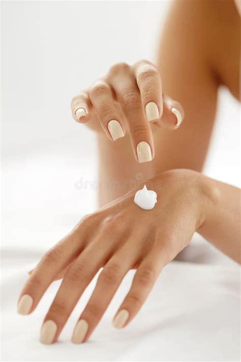Mani che applicano crema su un tatuaggio