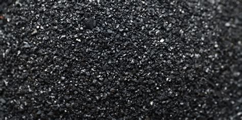 Immagine stilizzata di particelle di carbone attivo che assorbono impurità