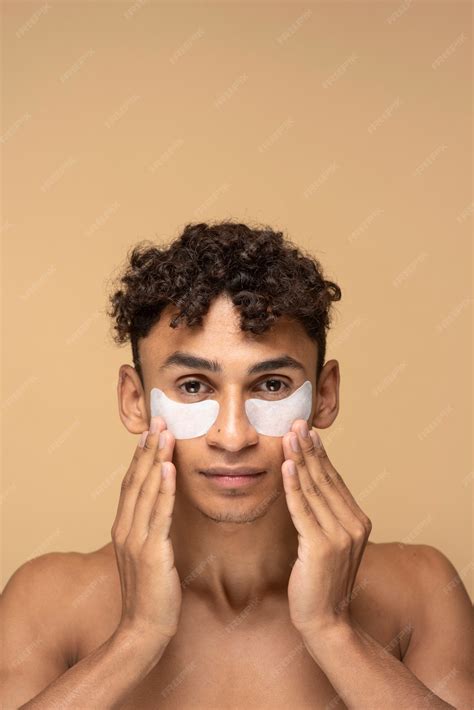 uomo che applica correttore sotto gli occhi