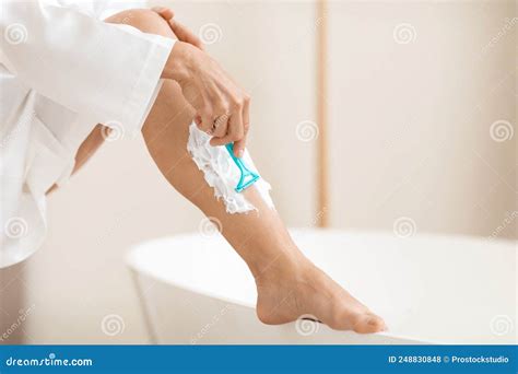 Donna che si depila le gambe con un rasoio