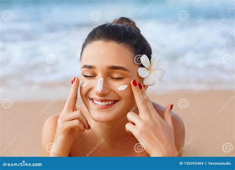 Donna che applica crema solare su un bambino