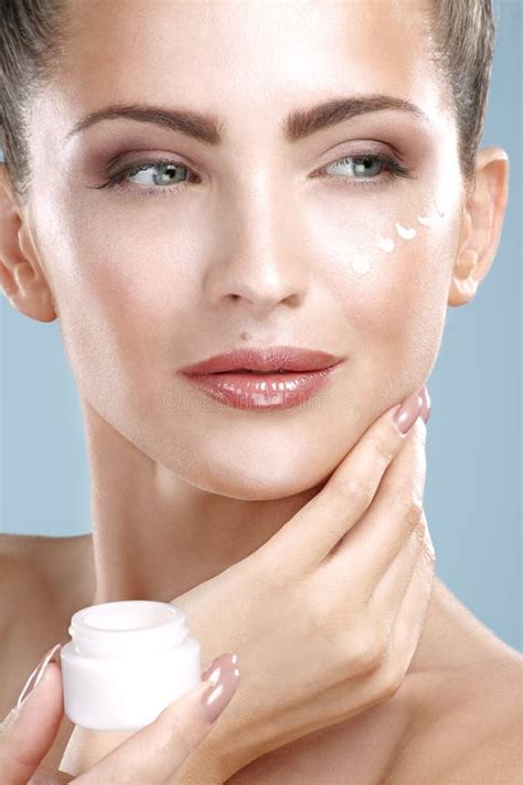 Donna che applica un trattamento viso