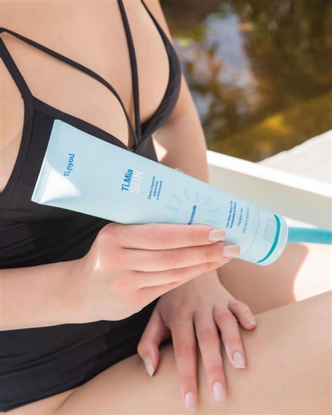 Una persona che si applica un balsamo doposole sulla pelle abbronzata dopo una giornata al mare