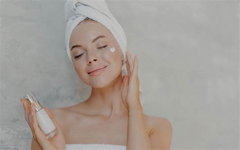 Donna che applica una fiala di siero sulla pelle del viso