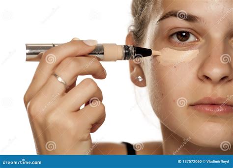 Donna che applica un correttore per macchie