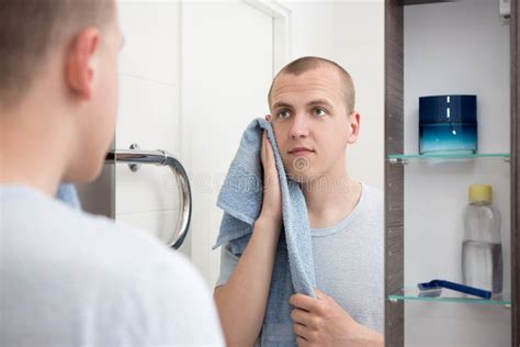 Uomo che si guarda allo specchio dopo la rasatura