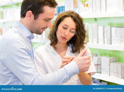 Persona che consiglia prodotti dermocosmetici a un cliente in farmacia