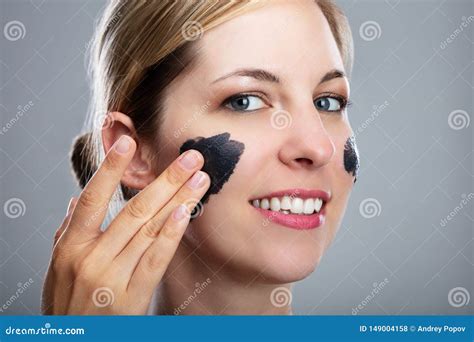 Donna che applica una maschera nera sul viso