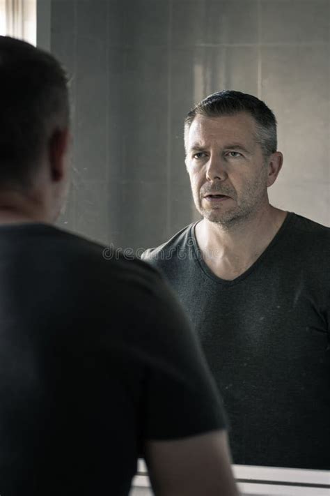 Uomo che si guarda allo specchio dopo aver applicato la crema