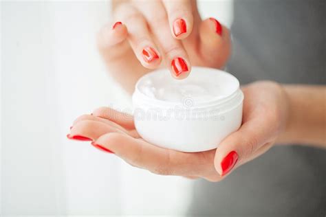 mani che ricevono un tubetto di crema