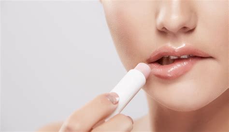 Una persona che applica un balsamo labbra