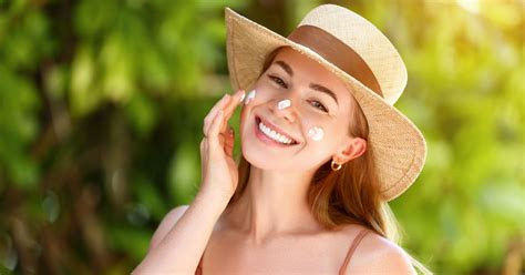 Persona che applica la protezione solare sul viso