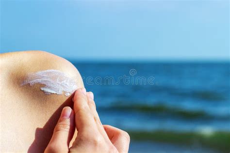 Immagine di una persona che applica lo spray solare su tutto il corpo in spiaggia