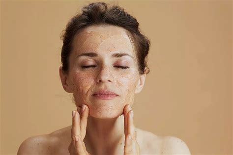 Donna che applica uno scrub viso