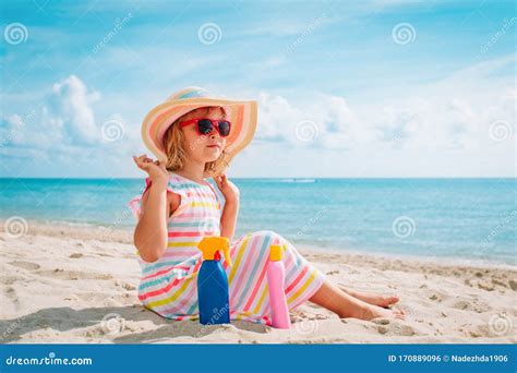 Ragazza con crema solare in spiaggia