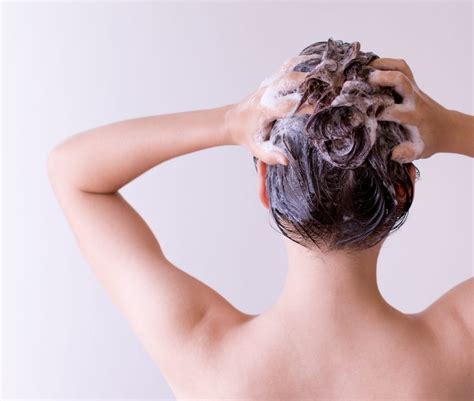 Donna che applica un trattamento pre-shampoo sui capelli