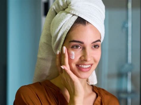 Persona che applica una crema sul viso di sera