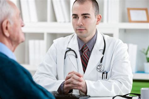 un medico che parla con un paziente in una sala visita