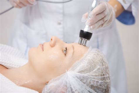 Professionista che applica un trattamento viso con strumenti high-tech