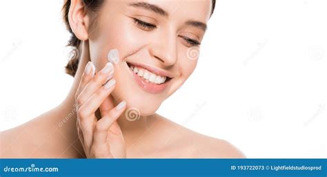 Donna che applica crema viso con sorriso