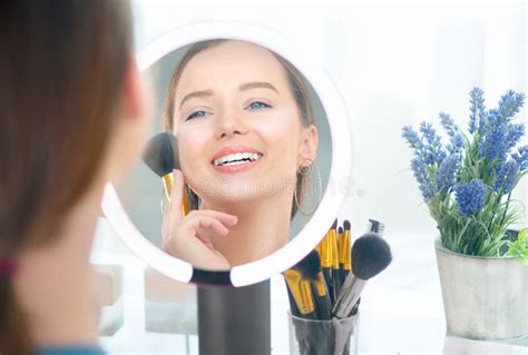 Donna con occhiaie che guarda uno specchio