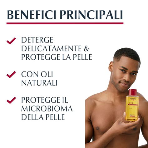 Persona che si insapona con olio detergente sotto la doccia