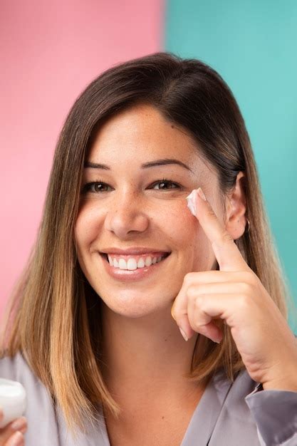Una donna che applica una crema viso idratante