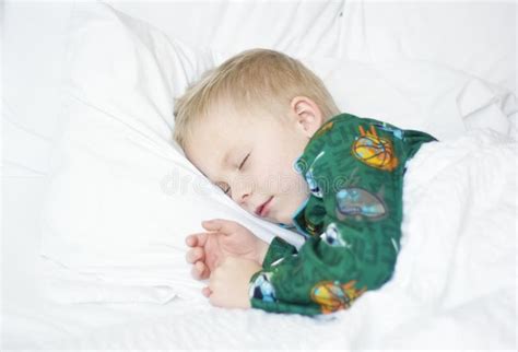 Bambino che dorme in un letto con biancheria a quadretti Vichy